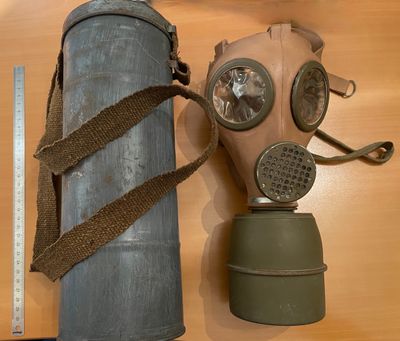 un masque à gaz et un bidon d'essence posés sur une table