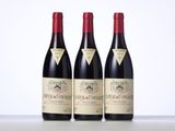 three bottles of red wine sitting on top of a table