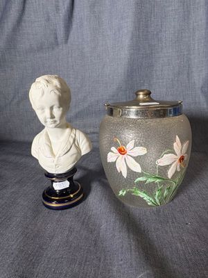 a vase with a bust of a woman next to a vase with flowers painted on it