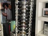 a rack with many pairs of sunglasses on it in a room