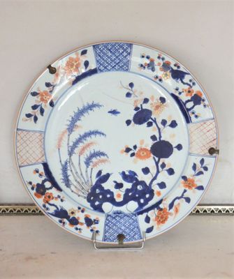 une assiette bleue et blanche ornée de fleurs orange