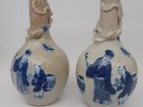 une paire de vases bleus et blancs ornés de personnages sur fond blanc