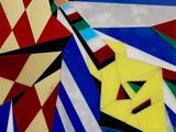 brightly colored kites are arranged in a circle on a black surface