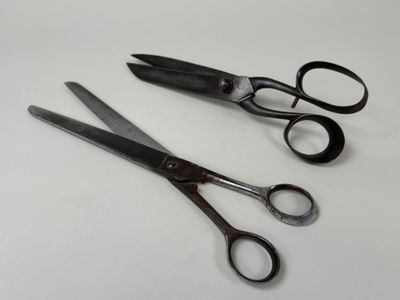 two pairs of scissors sitting on a white surface