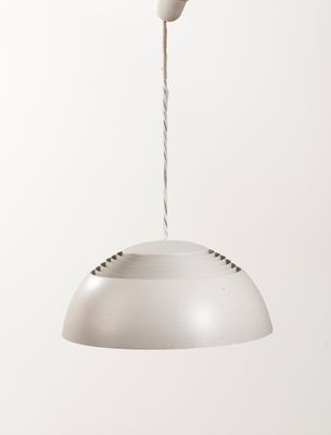 une personne tenant une lampe blanche suspendue au plafond