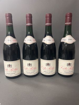 quatre bouteilles de vin sont alignées sur une table