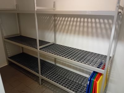 une étagère à plusieurs tablettes placée dans un coin de la pièce