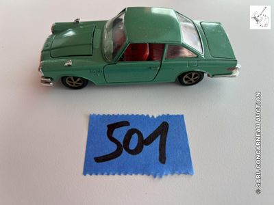 une petite voiture verte posée à côté d'un bout de papier sur lequel est écrit « so1 »