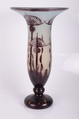 un vase en verre avec un tableau posé sur une table