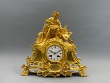 une horloge en or surmontée d'une statue