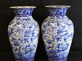 two blue and white vases sitting next to each other
