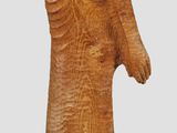 a wooden statue of a woman standing on a rock