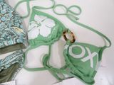 two bikinis and a ring on a white surface