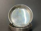 an antique silver plate sitting on top of a wooden stand
