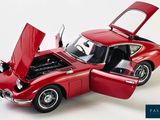 a red toy car with its hood open on a white background