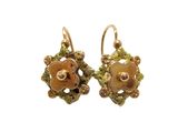 une paire de boucles d'oreilles dorées ornées de fleurs et de feuilles
