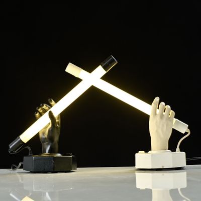 a lamp that is on a table with a hand