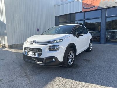 une citrole blanche garée devant un immeuble
