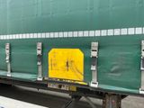 un wagon vert sur lequel est apposé un panneau jaune