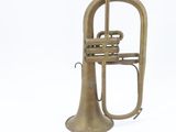 an old brass trumpet and other musical instruments on a white surface