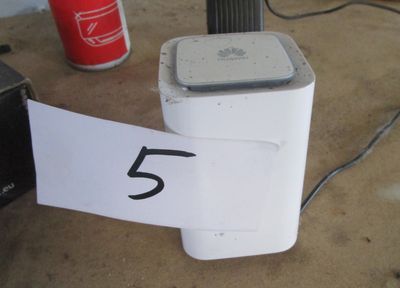 un réfrigérateur blanc sur lequel figure un numéro, à côté d'une canette de soda