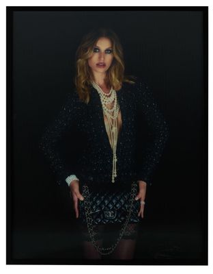 an image of a woman in a black jacket and skirt posing for a picture