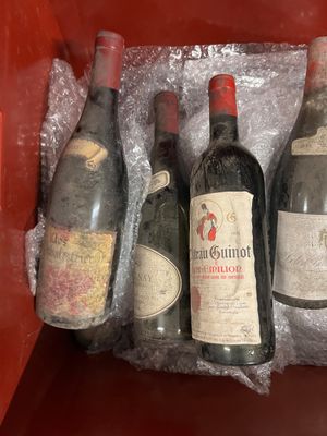 several bottles of wine are in a red box on a table