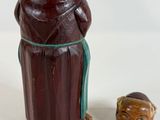 a figurine of a man and a woman next to a bottle of wine