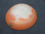 an orange and white helmet sitting on a black surface