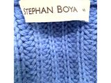 a close up of a blue sweater with a label on it