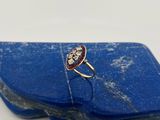 une image représentant une bague rouge et blanche sertie d'une pierre bleue