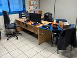 a room with a desk, chairs, and a computer on it