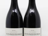deux bouteilles de vin rouge posées l'une à côté de l'autre sur une surface blanche