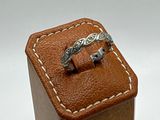 a ring in a wooden box on a white surface