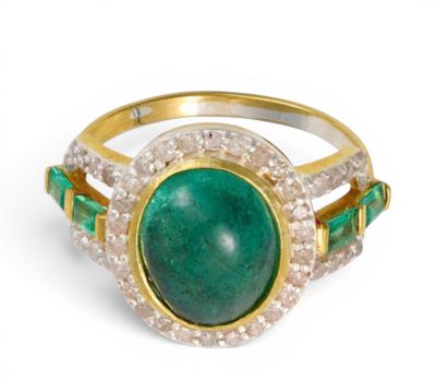 gros plan d'une bague avec une pierre verte entourée de diamants