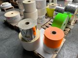 many rolls of colored tape on a pallet in a warehouse