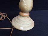 a green vase sitting on top of a table next to a cord