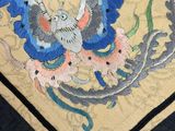 a close up of a rug with a bird and flowers on it