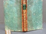 an old book with a bookmark on it sitting on a table