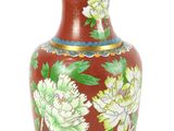 un vase rouge orné de fleurs blanches sur fond blanc
