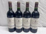 four bottles of wine are lined up on a table