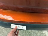 a person holding a sticker on the bumper of a car