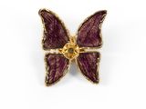 a close up of a purple butterfly broochle on a white background