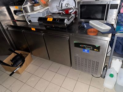 a kitchen with a lot of appliances and a lot of clutter on the counter