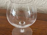 a clear glass on a wooden table with a white wall in the background