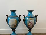 two blue vases sitting on top of a wooden floor next to a white wall