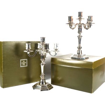 pair of silver plated candelabs and a box of candles