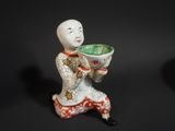 a figurine of a woman holding a bowl