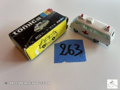 un petit bus miniature et un autocollant posés sur une table