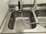 a stainless steel sink with two faucets attached to the faucet